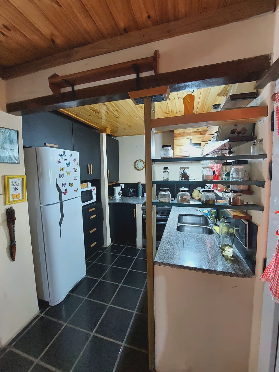 Cocina equipada con heladera con freezer, microondas, cocina con horno y mesada.