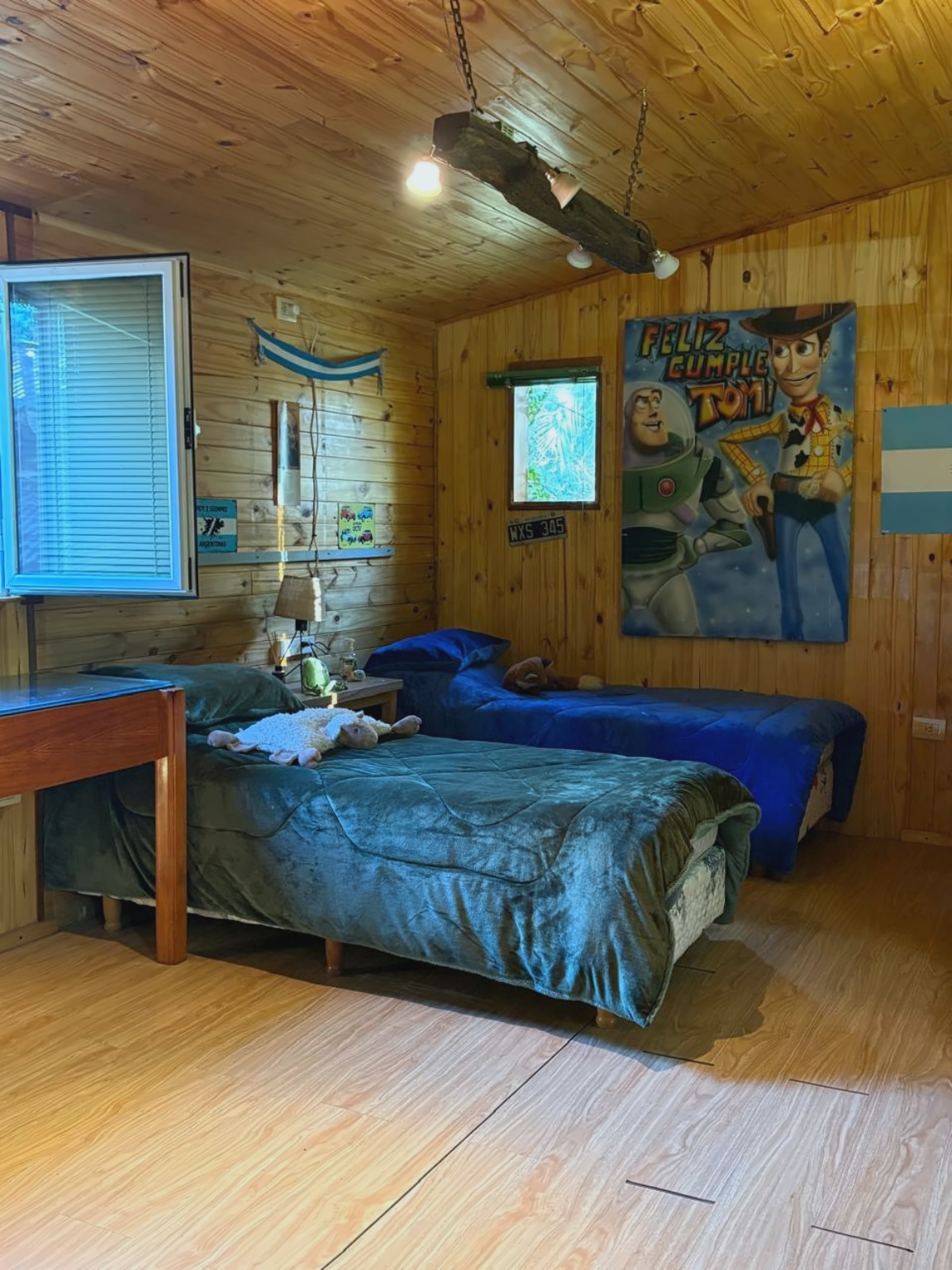 Dormitorio revestido en madera con dos camas individuales.